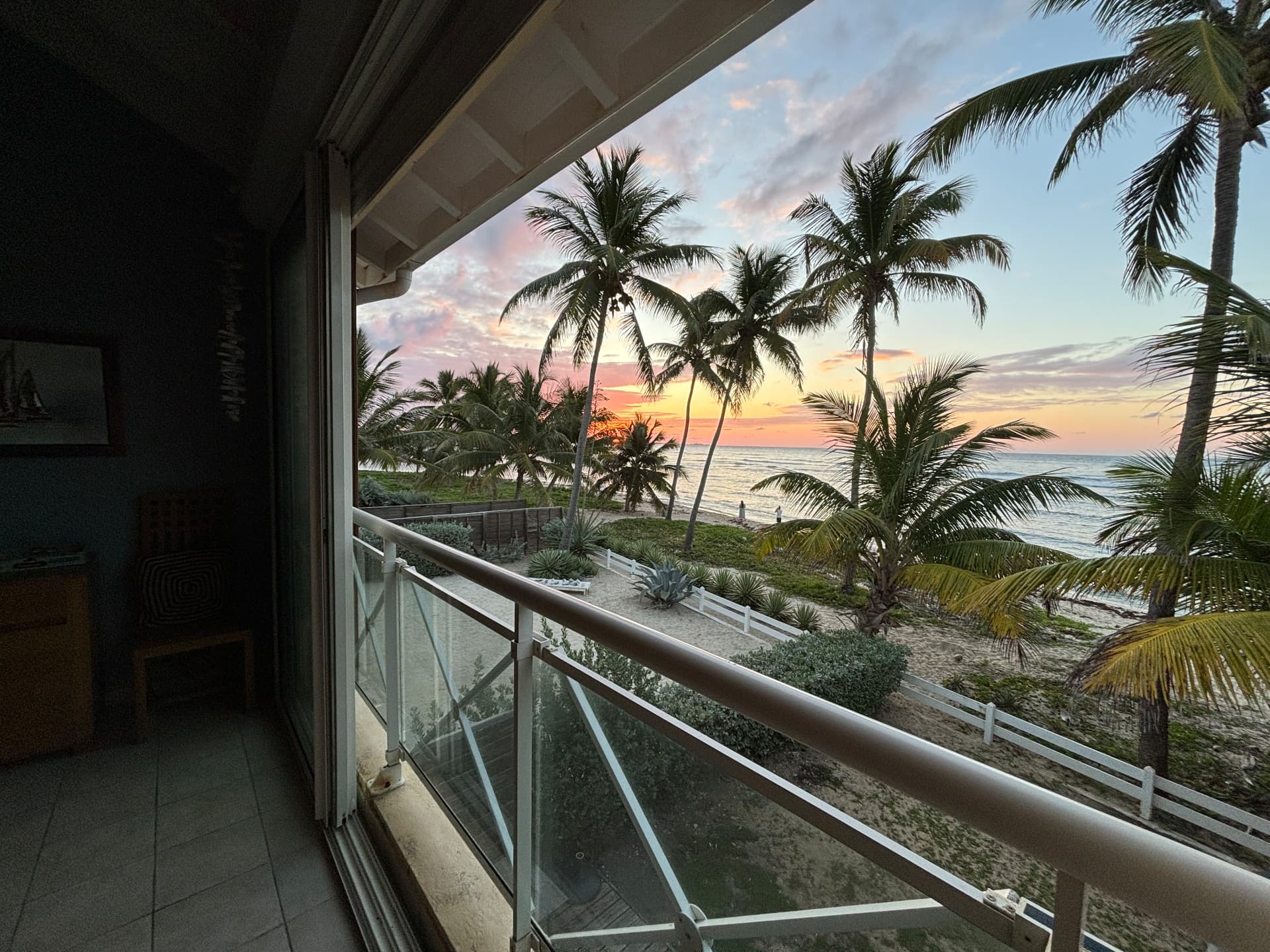 Vue sur la plage et les palmiers au coucher du soleil depuis le balcon