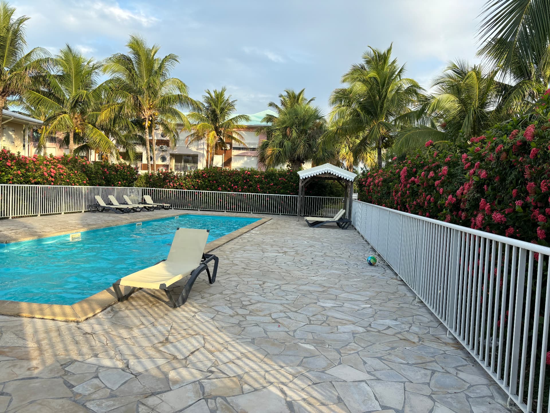 Seconde piscine de la résidence avec transats et carbet